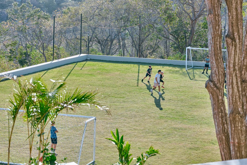 Students learning outdoors at Tambran School in a natural tropical setting