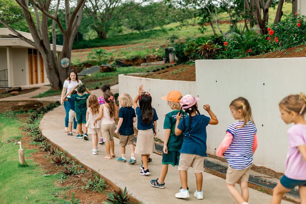 Students learning outdoors at Tambran School in a natural tropical setting